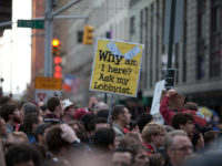 A protester holds a sign in Times Square by Geoff Stearns https://flic.kr/p/aw6XLr (CC BY 2.0)