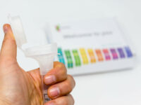 Hand holds Saliva Collection Kit Tube from 23andMe with open funnel lid to test health and ancestry with personal genetic in front of blurry background by Marco Verch https://foto.wuestenigel.com/?utm_source=46741832614&utm_campaign=FlickrDescription&utm_medium=link https://flic.kr/p/2edq7nL (CC BY 2.0)